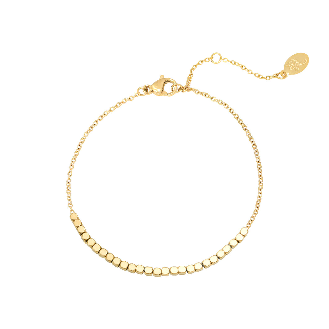 een mooi goudkleurig trendy armbandje met vierkante kraaltjes